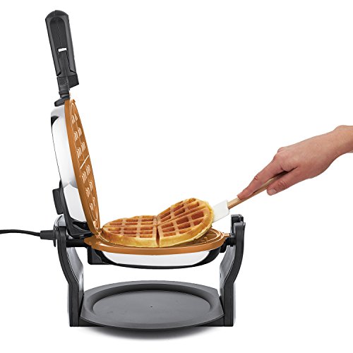 a cooked waffle being taken out of a Bella titanium copper rotating waffle maker 