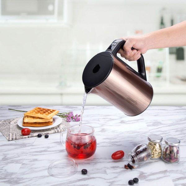 electric kettle pouring hot water into glass mug on kitchen counter